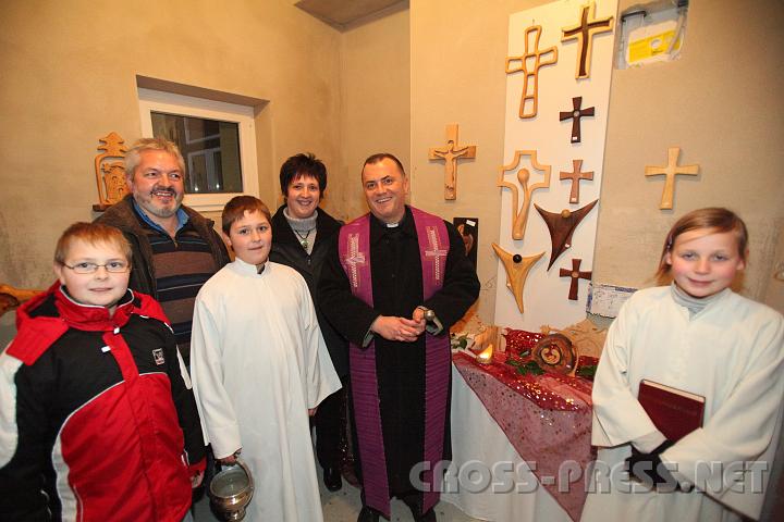 2009.11.28_20.51.24.jpg - Auch die sehr originellen Holz-Exponate, Kruzifixe und Krippen des begabten Schnitzk�nstlers Herbert Rettensteiner wurden gesegnet.  Am Bild v.l.n.r.: Dominik, Herbert und Rosemarie Rettensteiner mit Sohn Tobias und Helena Krenn als Ministranten mit Pfarrer Mag. Jacek Biela.