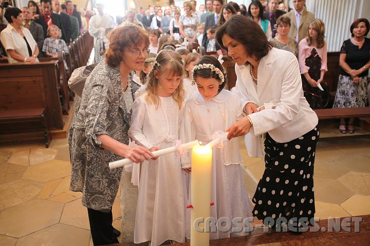 2009.05.21_10.03.30.jpg - Die Klassenlehrerinnen Leichtfried und Gruber helfen beim Anz�nden der Erstkommunionskerzen an der Osterkerze.