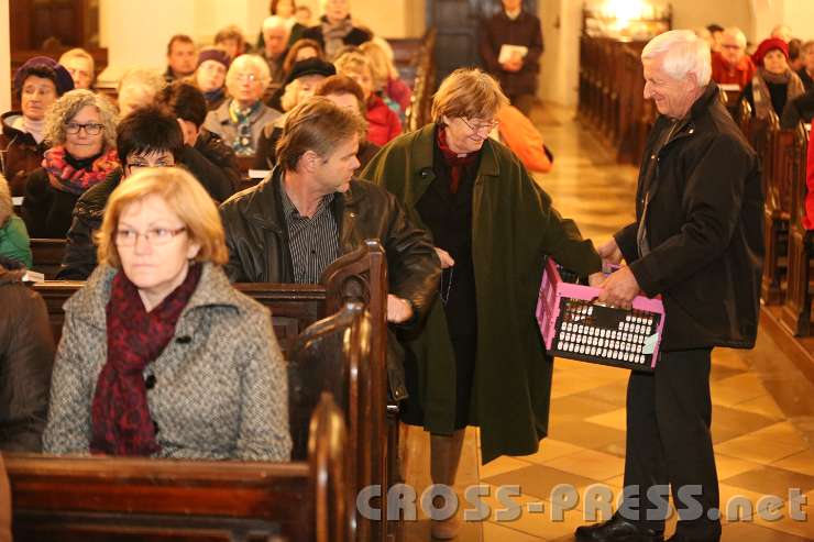 2014.11.23_17.19.48.jpg - Liederbücher werden ausgeteilt.