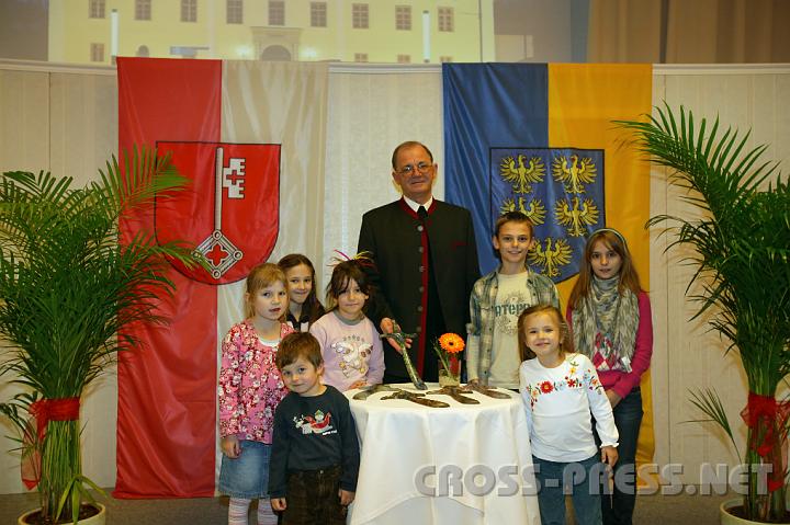 2008.11.08_13.02.35.JPG - Pfarrer Anton Schuh pr�sentiert mit Gabriel, Hanna, Timna, Mara, Antonio, Marina und Noemi die f�r diesen Anlass von K�nstlerin Monika Karlinger handgefertigten "Schlosskreuze" aus Keramik.
